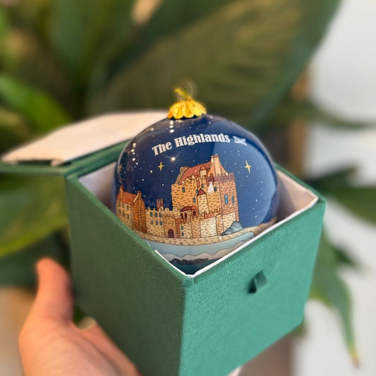 Dark blue Scottish Christmas decoration bauble with castle illustration and The Highlands text