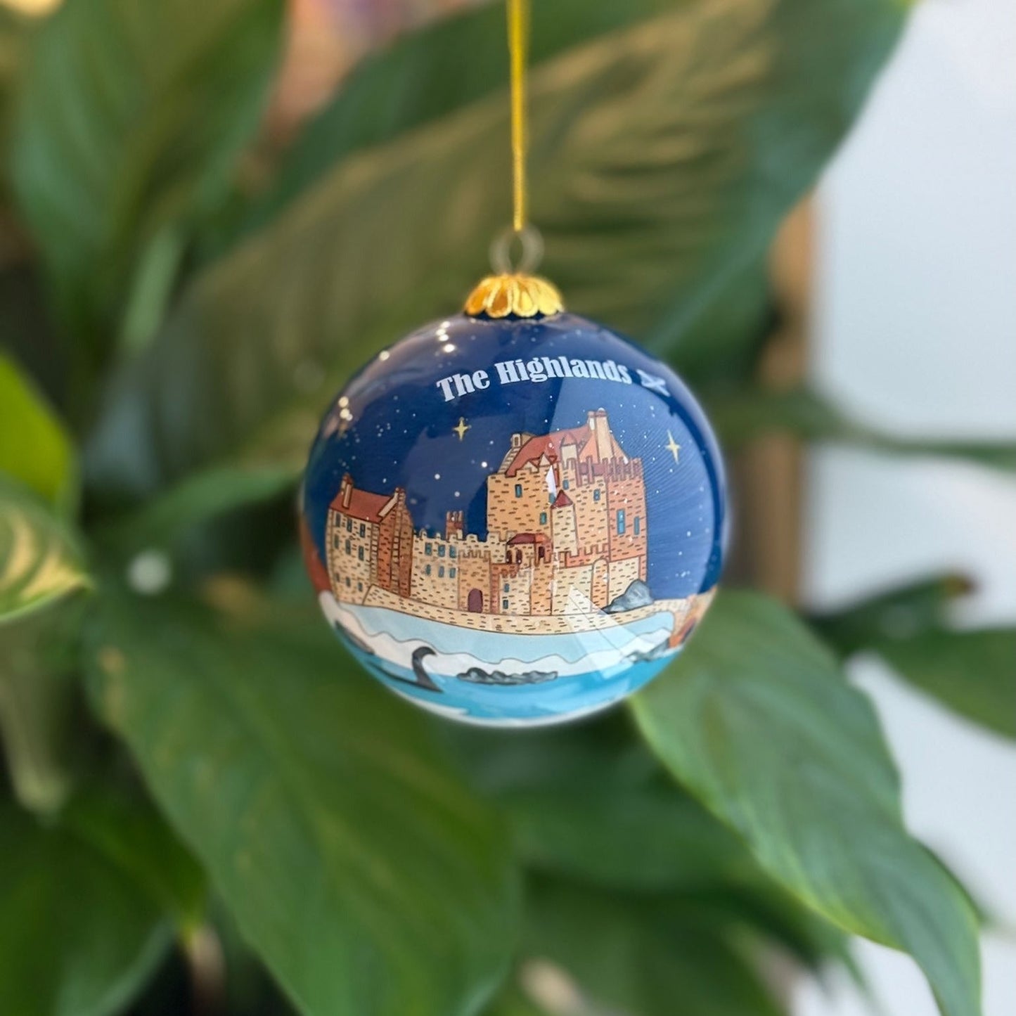 Blue Scottish Christmas decoration bauble featuring a castle, water, and starry sky